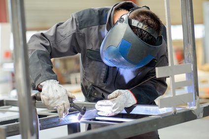 Man leaning over welding